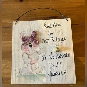 Wooden sign. “Ring bell for maid service. If no one answers, do it yourself.”